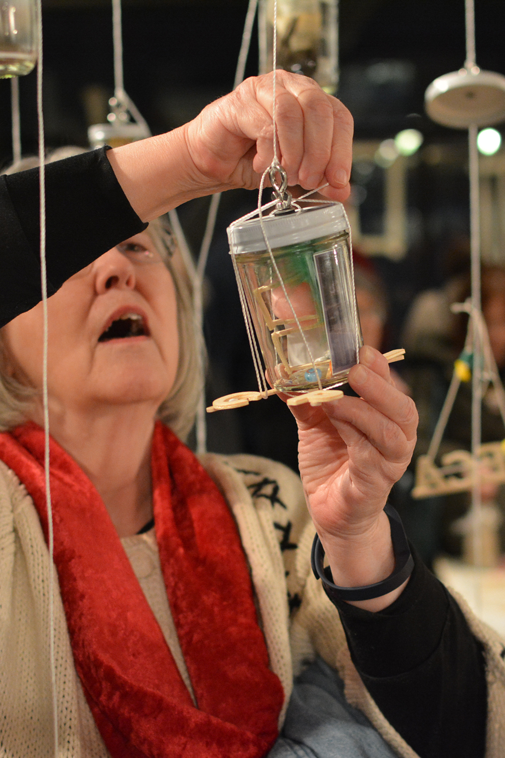 A visitor working to hang the jar she made during the opening reception.
